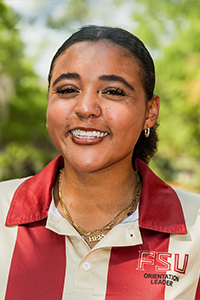 smiling female student with brown hair pulled back into a bun at the base of her skull
