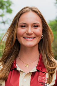 smiling female student with long blonde hair and hoop earrings