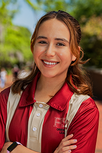 smiling female student with mid-length brown hair with crossed arms