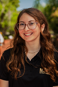 smiling female student with wavy red hair and oversize glasses