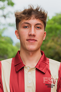 smirking male student with short hair with spiked bangs, stud earrings and a stud in his nose