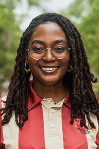smiling female student with glasses and hair in shoulder-length twists